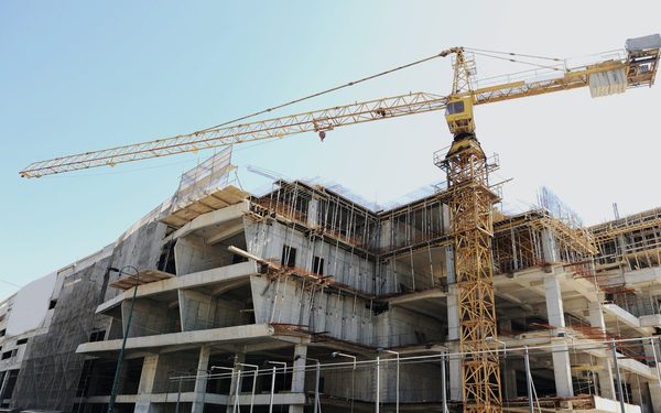 Tower crane working over a multi story commercial building under construction