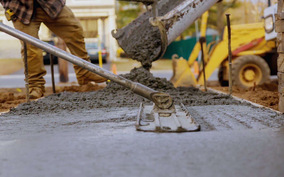 Concrete being placed from a pump hose onto a prepared and reinforced slab area