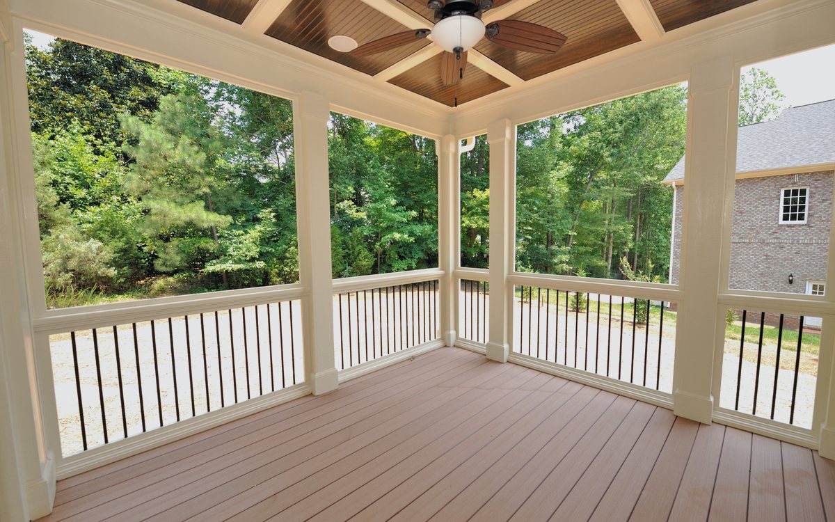 Covered wood deck with white railing, a ceiling fan, and a finished composite deck surface
