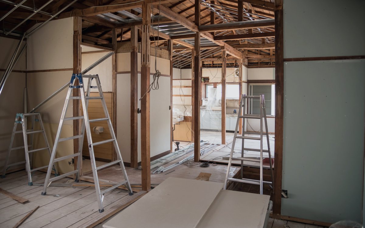Interior stripped back to the studs during a gut renovation, with ladders and new framing in place before rough in begins