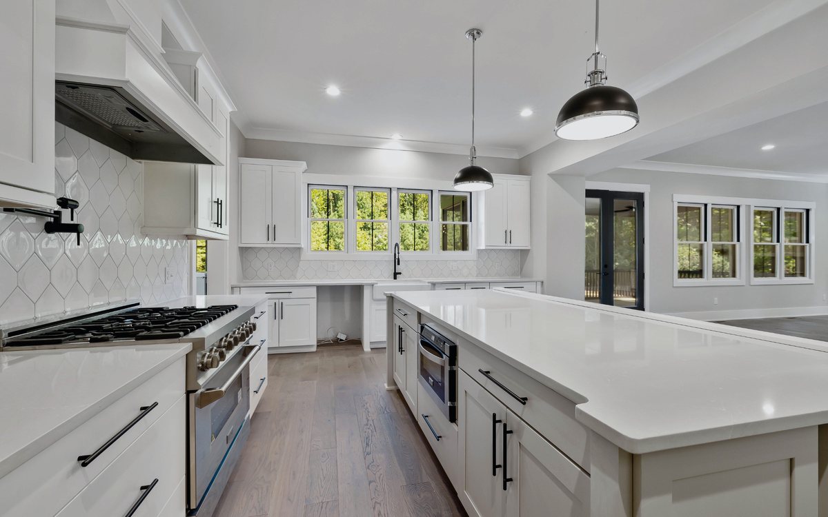 Finished white kitchen remodel with a quartz island and pendant lighting in Valencia